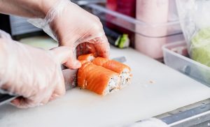 chef hands cutting sushi roll in the kitchen 2025 03 16 18 45 42 utc