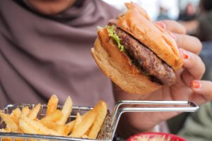 woman hand holding a beef burger enjoying her meal 2024 12 13 14 46 24 utc 1