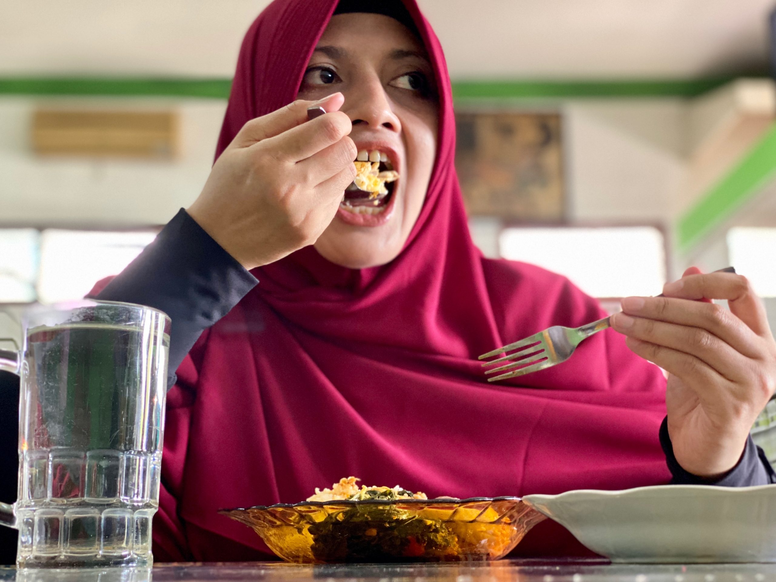 Muslim Solo Traveler’s Halal Food Survival Guide 8 young woman having lunch and take a bite for rice 2024 12 01 15 18 18 utc scaled