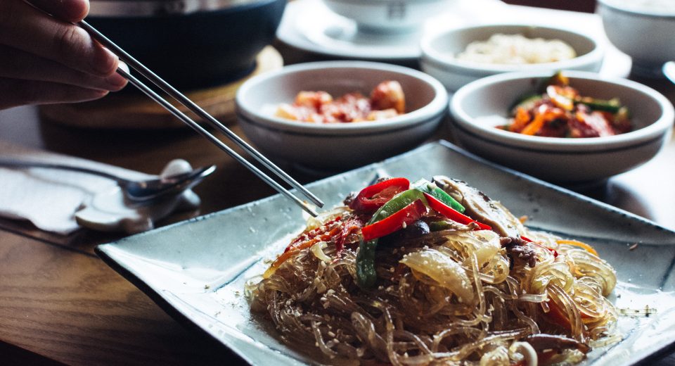 man eating korean glass noodles with chopsticks 2024 09 17 17 05 19 utc