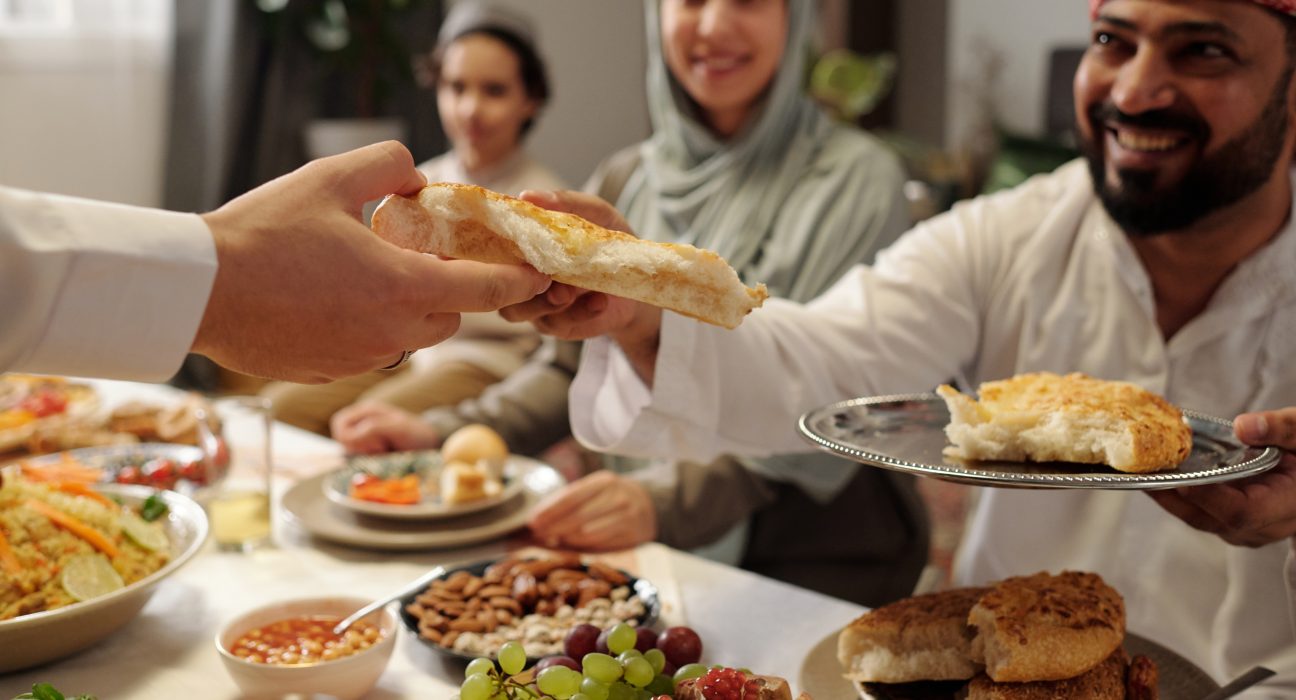 muslim family sharing flatbread at festive dinner 2025 03 15 04 17 28 utc