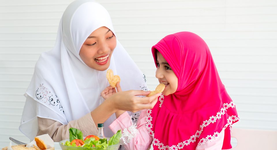 muslim mother and her daughter are eating cookies 2025 03 09 17 00 21 utc