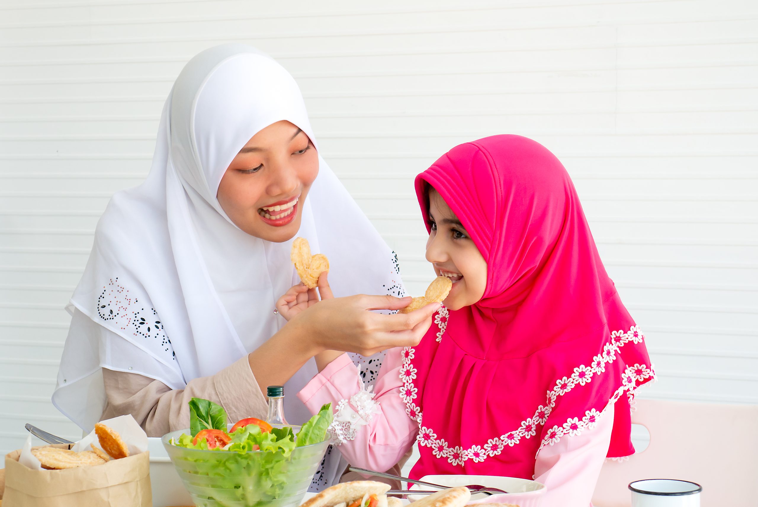 muslim mother and her daughter are eating cookies 2025 03 09 17 00 21 utc scaled