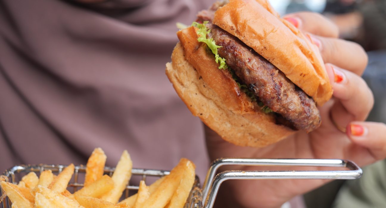 woman hand holding a beef burger enjoying her meal 2024 12 13 14 46 24 utc